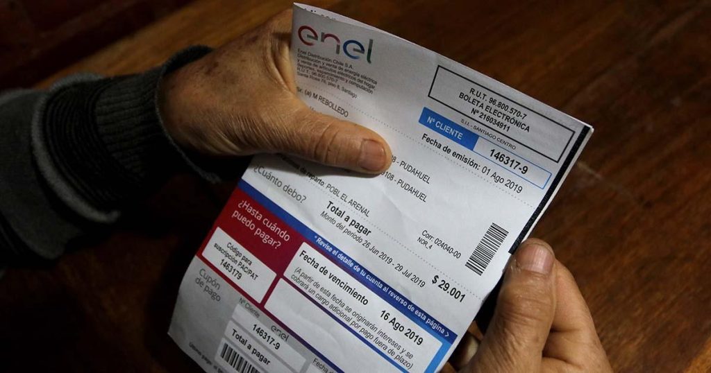Persona sosteniendo una cuenta de luz en Chile, ante la rebaja promedio del 4,3% en las tarifas eléctricas proyectada para enero de 2027.
